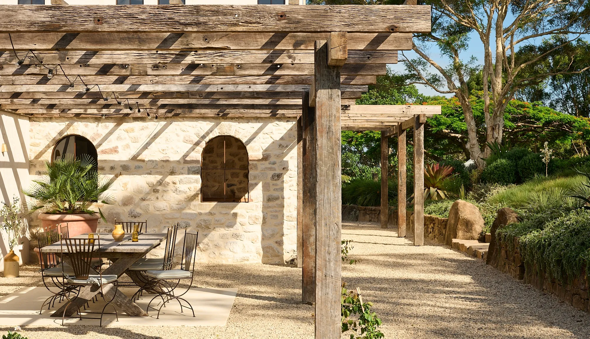 Recycled hardwood pergola beside a stone courtyard